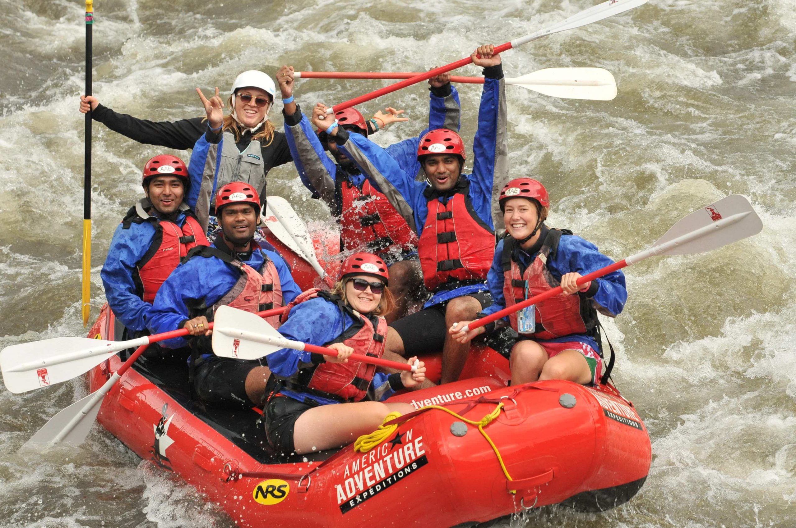 team poses on rafting during team building activity